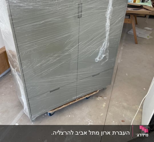 ארון עטוף בניילון על גלגלים בסביבה פנימית